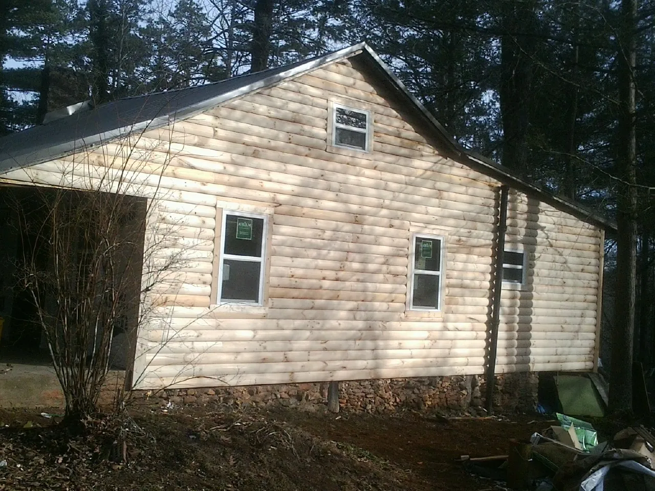 New log siding and dark metal roofing on a gable end in Mahanoy City