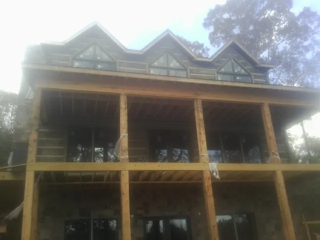 Dormers and porch framing on a large log home under construction — Roof Coating work by our crew in Mahanoy City