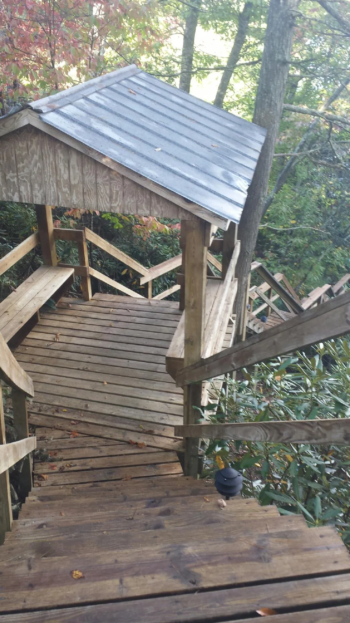 Metal roofed shelter over wooden steps on a wooded walkway — Skylight Repair & Installation work by our crew in Mahanoy City
